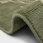 Sage green hand knotted wool rug with floral vine design handcrafted in Bhadohi India